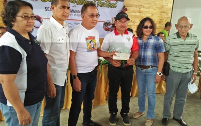 <p><strong>INDEMNITY CLAIMS.</strong> Agriculture Secretary Emmanuel Piñol (3rd from right) turns over to Rural Bank of Miag-ao manager Rey Flores (3rd from left), PHP977,000 worth of indemnity claims of 80 farmers affected by calamity in Miag-ao, Iloilo on Friday (May 4, 2018). <em>(Photo by Perla Lena) </em></p>